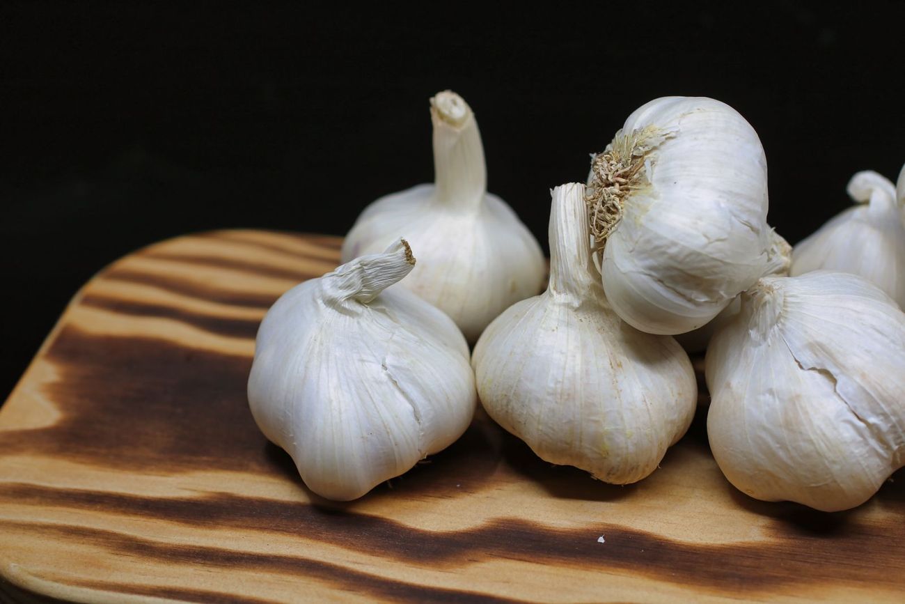 Cabeças de alho numa tábua de madeira